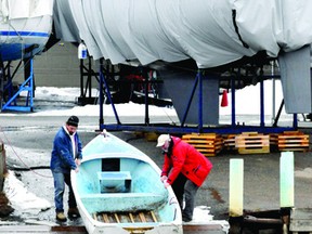 John Panter, left, and John Donaghue pull a boat a little further up the ramp at the Brockville Yacht Club as Buell's Creek continued to rise this week. (DARCY CHEEK/The Recorder and Times)