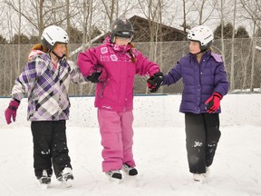 Classmates Leah Ambeault and Maddie Pollock help Alexis Stinson navigate during outdoor activities.