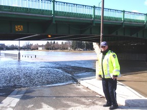 Ken McIntyre of Chatham watches as rising water covers the roadway under Fifth Street Bridge. (Chatham Daily News)