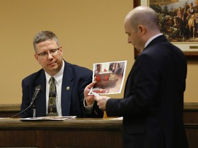 Prosecuting attorney Brian Deckert (R) holds up a photograph in evidence for witness and Bureau of Crime Investigation Special Agent Ed Lulla (L) in juvenile court in Steubenville, Ohio, March 14, 2013.  REUTERS/Keith Srakocic/Pool