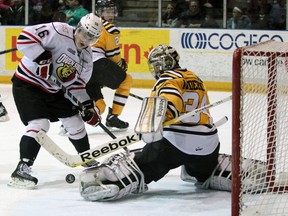 Daniel Milne (16) of the Owen Sound Attack and Sarnia Sting goalie J.P. Anderson watch a rebound after Anderson made a save Friday, March 15, 2013 at the RBC Centre in Sarnia, Ont. PAUL OWEN/THE OBSERVER/QMI AGENCY