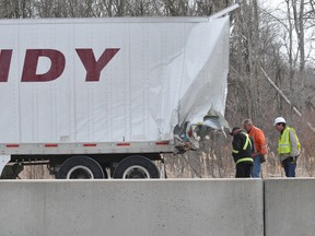 Workers examine the damage to a trailer involved in a 20-vehicle pileup on Highway 401 east of Prescott. Two people, including a driver in one of four transports involved, are in Kingston hospital with serious injuries. Both eastbound lanes were closed more than 20 hours, before reopening Saturday afternoon. (NICK GARDINER/The Recorder and Times)