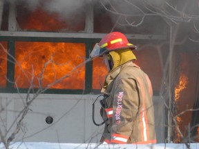 A firefighter walks past the fire scene at 774 Auto on Old Goulais Bay Road.