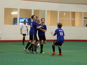 Members of the U14 Fury boys soccer team celebrate after Joey Moores broke the shutout to help the Fury win the bronze medal at the U14 indoor soccer tier II provincials Sunday at the Syncrude Sport and Wellness Centre. TREVOR HOWLETT/TODAY STAFF