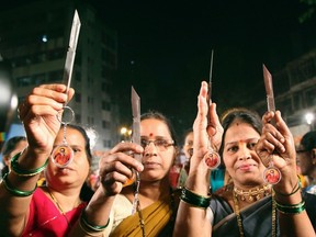 Indian women brandish knives distributed by the radical Hindu nationalist party Shiv Sena in a photo taken in January. The party handed out kitchen knives and chili powder to women in Mumbai following the gang-rape of a student that ignited a national debate on how to deal with sex crimes.
