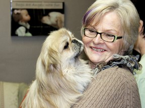 Anne Marie Belanger of Wyoming comforts 2-year-old Mars, a male Pekingese, moments after seven dogs arrived at CK Animal Rescue headquarters in Chatham, Ontario, after a two-day journey from Alabama last weekend. Photo taken on Sunday March 17, 2013. VICKI GOUGH/ THE CHATHAM DAILY NEWS/ QMI AGENCY