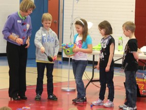 Carol McCloud directs Clandonald Grade 2 students in a skit to help the younger kids understand the bucket method.