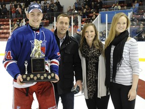 Sarnia native Adam Craievich, left, holds the Tim Adams Memorial Trophy as OHL Cup MVP while posing with Adams' family in Mississauga Sunday. AARON BELL/OHL IMAGES