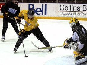Davis Brown, centre, of the Sarnia Sting, avoids a poke check attempt from goalie Brodie Barrick as Matteo Ciccarelli, left, looks on during the team's practice Monday, March, 18, 2013 at the RBC Centre in Sarnia, Ont. PAUL OWEN/THE OBSERVER/ QMI AGENCY