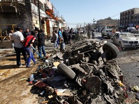Residents gather at the site of a car bomb attack in the AL-Mashtal district in Baghdad on March 19, 2013. (REUTERS/Mohammed Ameen)