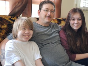 Kyle Robinson, 14, it's believed is one of four people in the world with a rare form of Castleman's disease. Doctors believe a tumour had been stalling his growth for years until 90% of it was recently removed. He's pictured here with his father Jeff and sister Coral, 16. (TYLER KULA, The Observer)