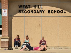 Students read outside West Hill Secondary School.