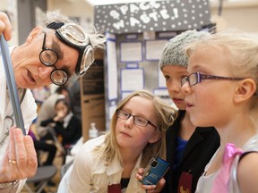 Banff Elementary School students Abi Smythe, Madi Carr and Amelia Capel look on as resident mad scientist “Professor Boffin” demonstrates his anti gravity machine at the science fair Tuesday, March 19. Glenn Kelly/ Banff Crag & Canyon