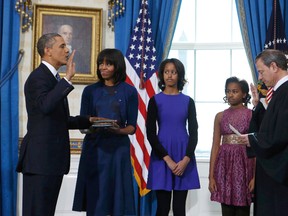 U.S President Barack Obama (L) takes the oath of office from U.S. Supreme Court Chief Justice John Roberts (R) as first lady Michelle Obama holds the bible and daughters Malia (3rd-L) and Sasha look on in the Blue Room of the White House in Washington, January 20, 2013. (REUTERS/Larry Downing)