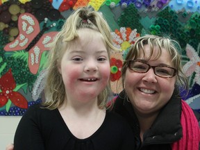 Lori Veley-Jenkins, giving a hug to her daughter Emma at Archbishop O'Sullivan School Tuesday morning, has made over 300 bracelets she will hand out to the students on Thursday to mark World Down Syndrome Day. (Michael Lea The Whig-Standard)