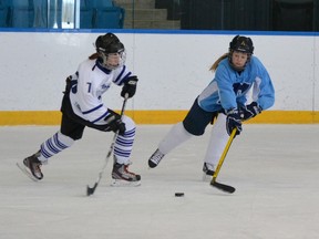 Timmins High Blues player Sydney Lia, left, winds up to fire the puck towards the opposing net during Monday’s loss against the St. Theresa Titans from Belleville at the OFSAA championships being played this week in Orillia. The Blues ended up making the quarter finals but were eliminated after losing the opening game in that series to a team from Ottawa.