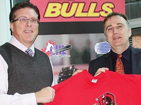 Belleville Bulls majority owner, Gord Simmonds, of Uxbridge, presents a playoff T-shirt to mayor Neil Ellis during a press conference Tuesday at the Sports Centre. (Paul Svoboda/The Intelligencer)