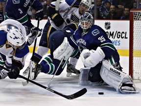 St. Louis Blues Andy McDonald (left) dives while trying to score on Vancouver Canucks goalie Cory Schneider during Tuesday's game in Vancouver. (REUTERS)