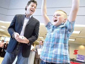 Little Brother Kiya Dietrich, 12, celebrates during his Wii bowling match with Bowl for Kids Sake ambassador David Keeley at Wednesday's kickoff at Scotiabank in downtown Stratford. (SCOTT WISHART, The Beacon Herald)