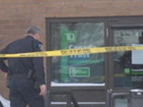 A police officer enters TD Canada Trust at Cambrian Mall on Wednesday, March 20, 2013.