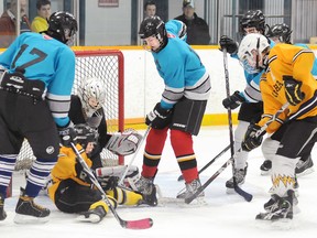 Members of the Sharks and Yellow Jackets battle for a loose puck in a goalmouth scramble during Super Sunday Bantam Division playoff championship action at the Community Gardens. The Yellow Jackets claimed the title with a 5-3 victory.