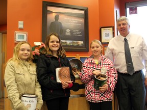 Emily Cox, left, Emma Lawlor and Madison DiSalvo of Beverly Central School present Tim Hortons of Paris owner Rick Bowler with 10,159 pennies (about 60 pounds) they collected in February to donate to the Tim Horton Children's Foundation. The money will help underprivileged kids attend the Onondaga Farms camp near St. George. MICHAEL PEELING/The Paris Star/QMI Agency