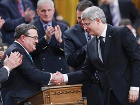 Federal Finance Minister Jim Flaherty shakes hands with Prime Minister Stephen Harper (R) after he delivered the federal budget in the House of Commons on Parliament Hill in Ottawa March 21, 2013. REUTERS/Chris Wattie