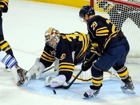 Buffalo Sabres goalie Ryan Miller (30) reaches to cover up the puck as right wing Jason Pominville tries to clear the puck, against the Toronto Maple Leafs (REUTERS/Doug Benz)