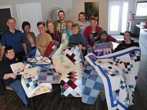 Residents, board members, employees and representatives of the Northern Lights Quilting Guild show off the donation at Greentree Group Home on Wednesday, March 20.