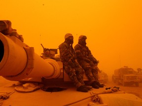 U.S. soldiers on alert for chemical weapons attacks during a sandstorm in the Iraqi desert shortly after the war began.