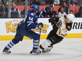 Dougie Hamilton of the Boston Bruins is knocked to the ice by John-Michael Liles of the Maple Leafs last night. (Claus Andersen/Getty Images/AFP)