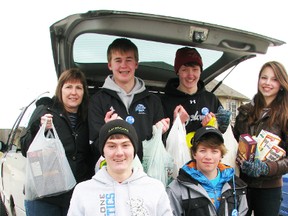 Teams of volunteers with Cyclone Aid fanned out across the community Saturday to collect for the Inn of the Good Shepherd food bank. Driver Kelly Lange, left, drove Kurtis Tanning, 16, Brodie Bresette, 15, Kendra Hoek, 14, Patrick Lange,16 (front left), and Jared Bourque, 15. (CATHY DOBSON, The Observer)