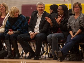 Prime Minister Stephen Harper, along his wife, Laureen, left, enjoy a laugh with fellow Ottawa Fusion volleyball parent Corinne Guy in the gym of Regiopolis-Notre Dame Catholic High School on Saturday afternoon. The Harpers were in Kingston to watch both their children play volleyball. (Jason Ransom PMO)