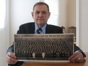 Wilf Garrah holds a picture of the staff at Kingston Penitentiary in 1967. (Danielle VandenBrink The Whig-Standard)