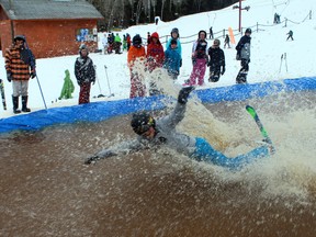 A participant takes a dunk in the slush pit at the last day of skiing at the Mount Evergreen in Kenora, ON.