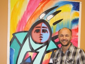 Alberta Golden Bears volleyball coach Terry Danyluk poses in his office at the Saville Community Sports Centre with a painting by Jerry Whitehead. Photo by Brian Swane/Edmonton Examiner