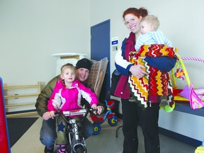 Lydia Carter, assisted by her father Bryan, tries out a bike  for sale at the Military Family Resource Centre Mar. 22, as mother Amanda and brother Noah look on. The sale of items, from baby size to teenager, was held over a weekend and included not only bikes but strollers, toys, clothes, books and other items. The twice-yearly event, sponsored by Babies First, raises money for various causes.