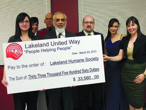 Ajaz Quraishi  of Lakeland United Way presents a cheque to Lakeland Humane Society shelter manager Dawn  Weber (from left) and incoming president Kathleen Boland (front right). Also in picture are (in back, left to right) Shauna Henderson, RCMP Sgt. Brent Sawatzky, Westlock-St. Paul MP Brian Storseth and Amel Storseth.