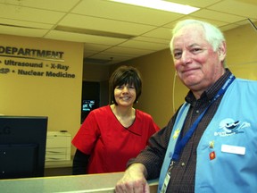 Ed Dennis, a volunteer at Brantford General Hospital, stands alongside registration clerk Janine Labron in the diagnostic imaging department.