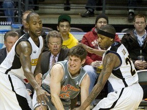 Moncton Miracles? Oliver McNally is fouled by Tim Ellis of the London Lightning, right, as he tries to break between Ellis and Elvin Mims during Game 1 of their NBL Canada semifinal at Budweiser Gardens on Monday. (CRAIG GLOVER, The London Free Press)