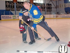 Officer Kevin Martin of the South Bruce OPP had a lock on Kincardine firefighter Paul Serratore during a meeting at the Davidson Centre on March 25, 2013. The pair exchanged fighting words in advance of the police versus fire charity hockey game set for April 6.