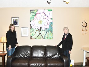 Becky Wells, director of Wellspring Family Resource and Crisis Centre and Sandy Dimond, stand beside Dimond’s painting that is on display at the centre.
Barry Kerton | Whitecourt Star