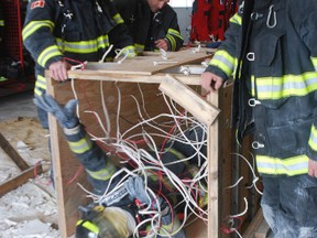 Woodstock firefighters crawled through an entanglement box as part of the deparment's safety training on Tuesday. (CODI WILSON/ Sentinel-Review)