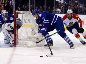 Maple Leafs Dion Phaneuf moves the puck around the net while being chased by the Panthers’ Quinton Howden last night. (Michael Peake/Toronto Sun)