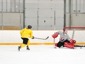 Canadian hockey legend Hayley Wickenheiser, sporting no-contact yellow jersey due to a nagging knee injury, takes one-timers at goalie Charline Labonté during a practice at the Silver Dart Arena on Tuesday night.