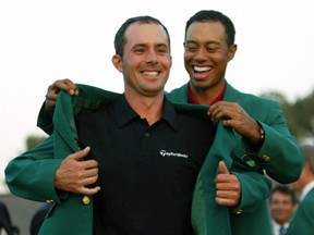 Mike Weir receives his green jacket from former champion Tiger Woods after Weir won the 2003 Masters Championship at the Augusta National Golf Club, April 13, 2003. REUTERS FILE PHOTO