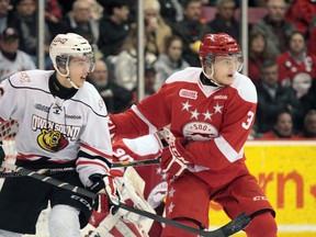 Daniel Milne of the Owen Sound Attack and Tyler Ganly of the Sault Ste. Marie Greyhounds keep an eye on the play as they jostle near the Greyhounds goal in the second period of Wednesday’s night OHL playoff game. The game went into sudden death overtime with Sault Ste. Marie finally winning 1-0.