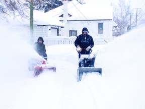 Peter Ralph, left, rides his early 70s "garage sale special" case tractor next to neighbour Ron Goodale's Snow King 8-Horse snow plow in Portage la Prairie. The two work together in the winter to clear the alleyway behind thier properties. (Svjetlana Mlinarevic/Portage Daily Graphic)