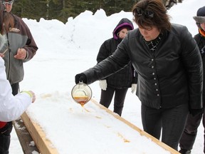 La Ruche President, Renelle Belisle pouring the warm maple syrup over the snow.