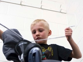 Zack Bigelow laces up his skates before getting on the ice during the Spring Break day camp hosted at the PCU Centre, Tuesday. (SVJETLANA MLINAREVIC/THE GRAPHIC/QMI AGENCY)